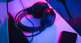photo of headphones lying on a shelf, bathed in blue and pink light