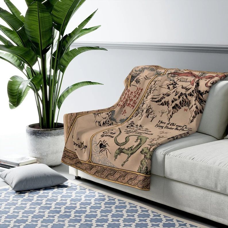 Photo of a blanket draped over a couch with a beautiful print of the map you can find in The Hobbit