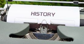 photo credit Markus Winkler. a close-up photo of a typewriter with a page that says HISTORY in big letters positioned in it.