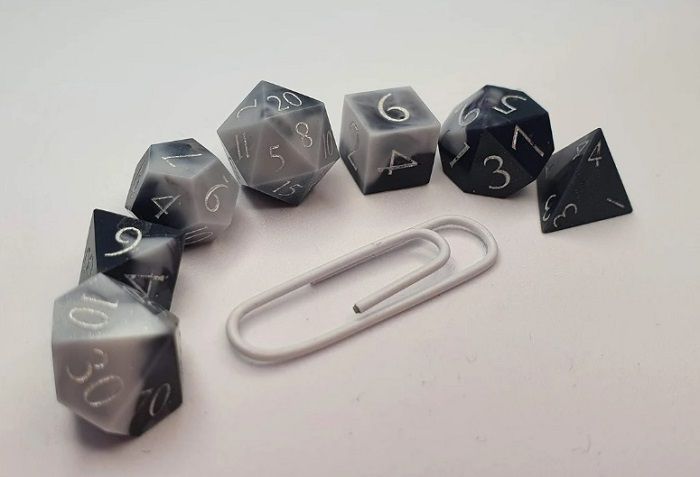 image of mini dnd dice set in milky opaque black and white with silver numbers on panels